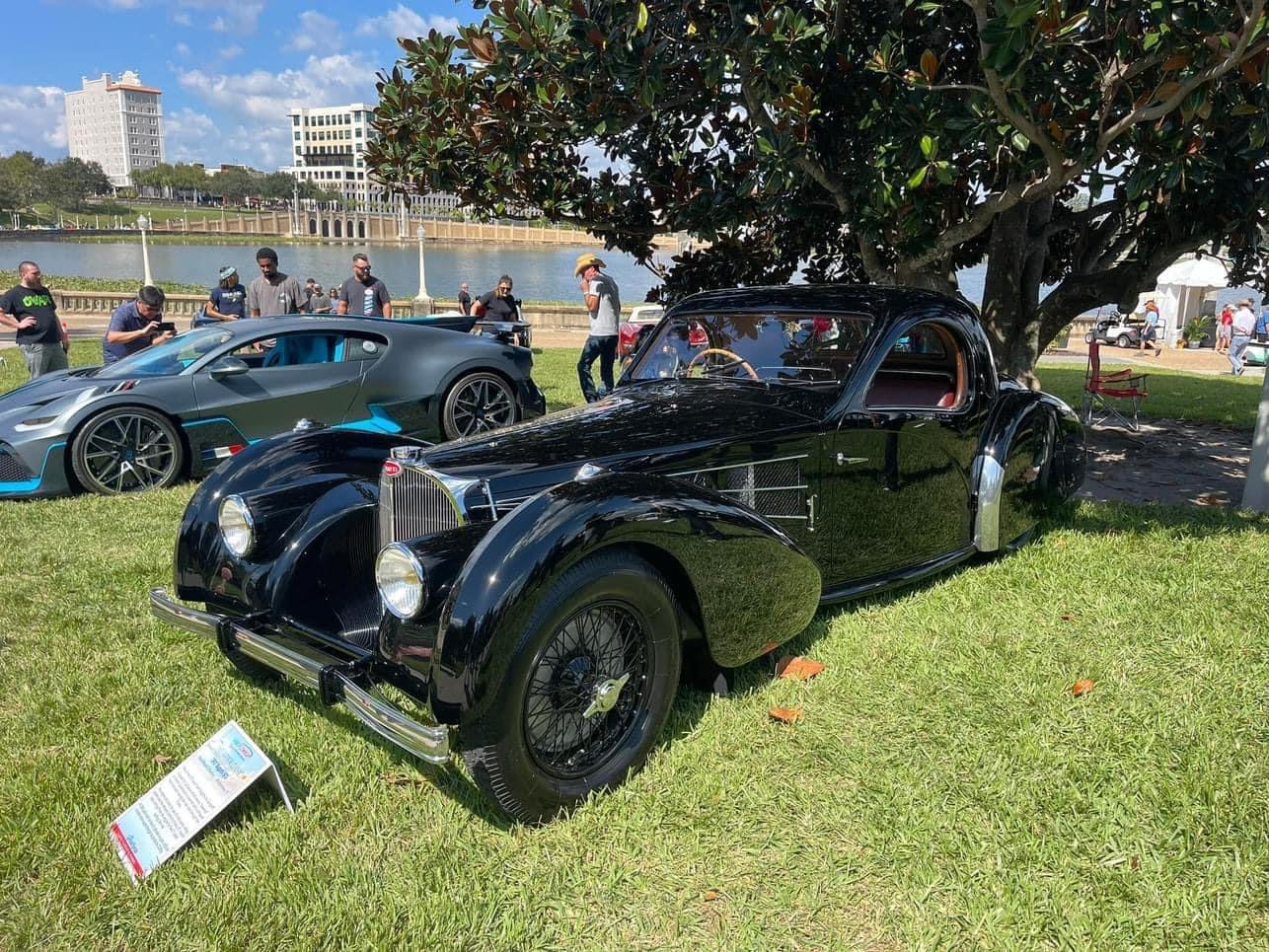 Judges evaluating a pair of Bugattis at the Concours d'Elegance